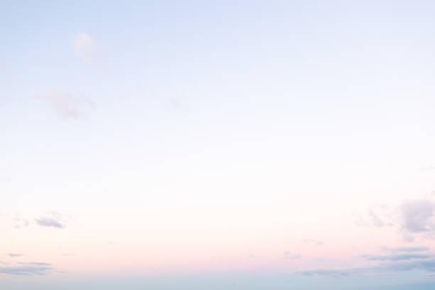 The horizon is painted with soft pastels as the sun sets, casting a peaceful glow