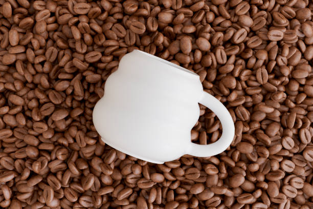 Red cup of coffee and coffee beans on the table