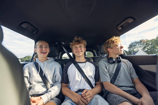 Teenagers riding in the back seat through the town of Dinan, Brittany. Three teenagers sit in the backseat of a car, being driven through a charming town of Dinan, Brittany, France.
Sunny, summer vacations day.
Shot with Canon R5 teenager boy driving stock pictures, royalty-free photos & images