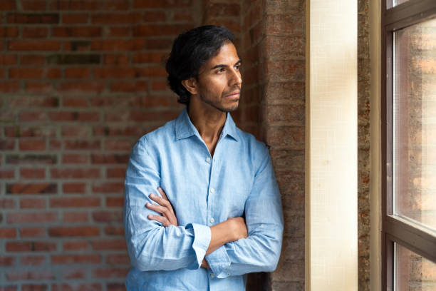 istock Thoughtful man looking through the window in loft apartment 2179322237