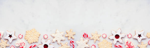 istock Christmas baking bottom border with assorted red and white theme cookies and candies on a white marble banner background 2179340882
