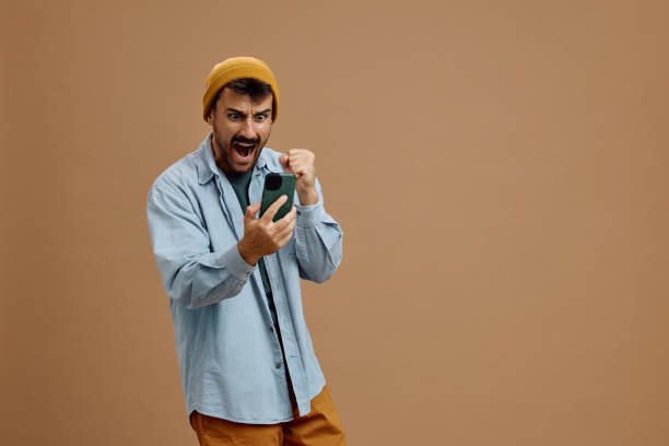 istock Studio shot of excited man shouting while using mobile phone. 2179342788