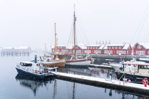 Red cottages and wooden ships in the snow, Svolvaer, Lofoten Islands, Norway