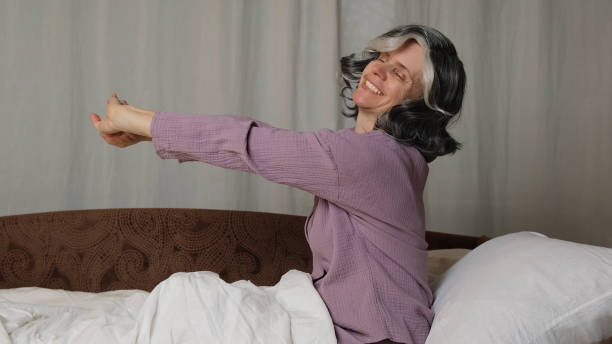 istock Senior woman doing stretches in bed. 2179363700