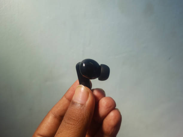 istock Holding a Black color TWS or Ear buds. Bluetooth Headset. 2179395455