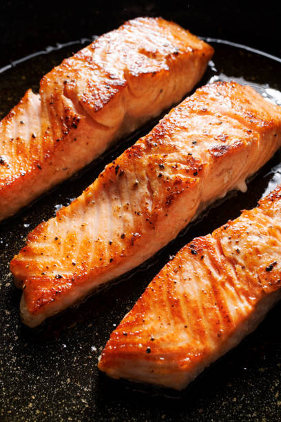 istock Baked salmon filets in a black baking dish, focus on the middle 2179400974