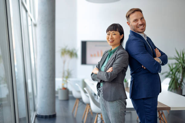 istock Confident colleagues stand back to back in office 2179415110