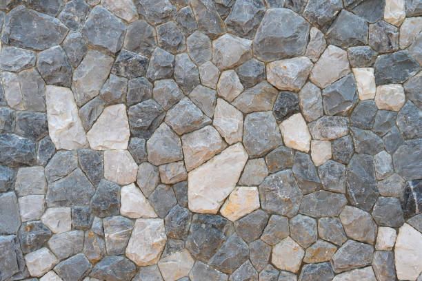 istock Closeup detailed view of a textured stone wall surface with natural patterns,rough and rugged textures,and a mix of grey,brown,and beige tones. 2179420232