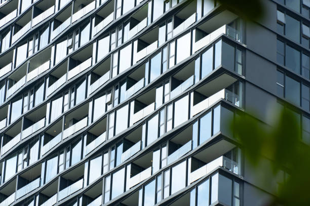 istock Striking architectural facade of a modern high-rise office building with captivating geometric patterns of glass windows and clean,minimalist design that reflects the surrounding city skyline. 2179420240