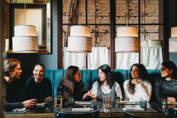 istock Group of friends enjoying dinner and conversation in a cozy restaurant 2179420903