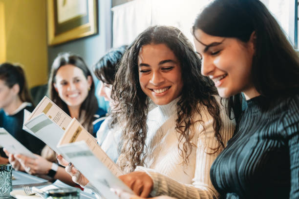istock Group of friends choosing from a restaurant menu smiling together 2179420927