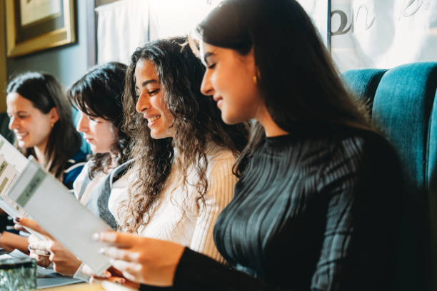 istock Young people choosing food from menus in restaurant 2179420928
