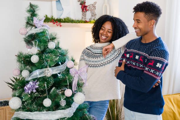 istock Young couple smiling and posing by christmas tree 2179424897