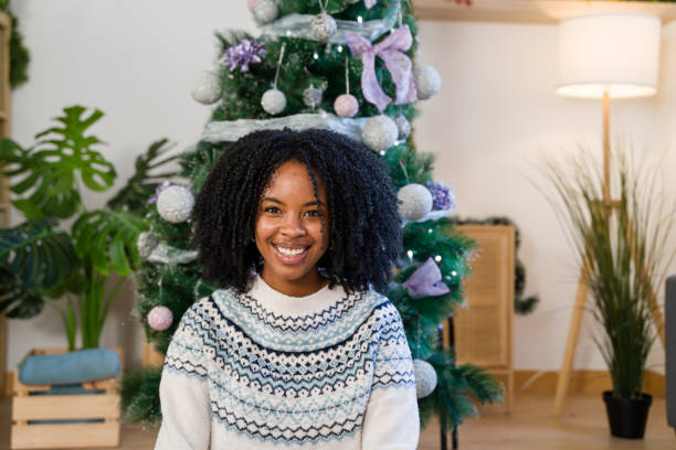 istock Woman smiling sitting near decorated christmas tree 2179425221