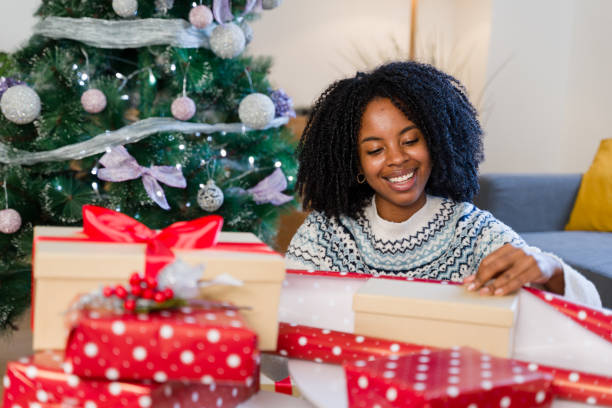 istock Woman wrapping christmas presents under the tree 2179426474