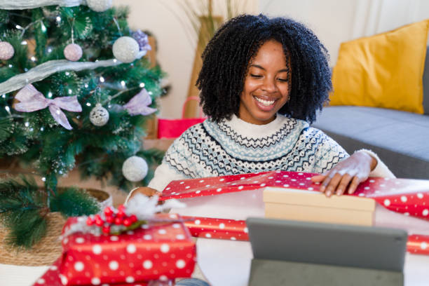istock Woman wrapping christmas presents while having a video call 2179426509