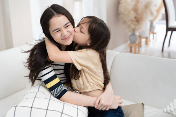 istock Smiling loving siblings hugging and kissing at home 2179427232