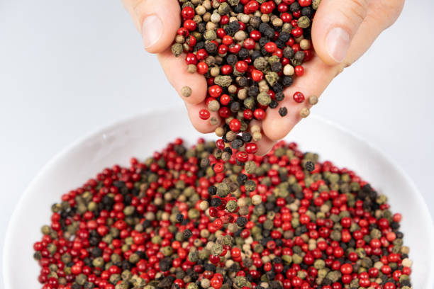 istock Hands sprinkling peppercorn mixture red, green, white and black pepper 2179430024