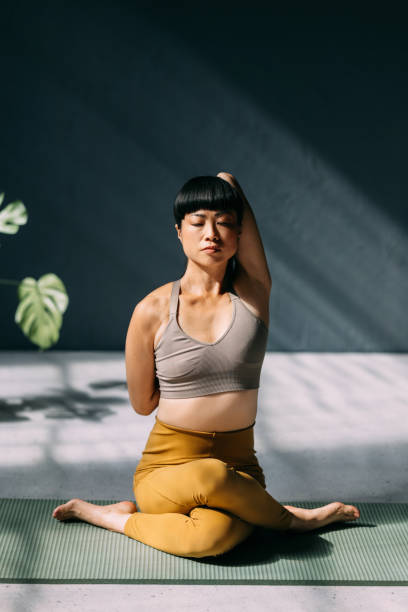 istock Woman Practicing Yoga with Mindful Focus in Sunlit Space 2179438432