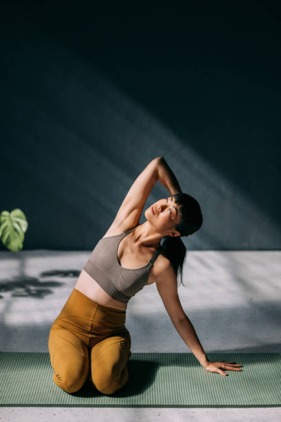 istock Peaceful Woman Practicing Yoga on a Mat in Natural Light 2179438435