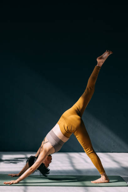 istock Woman Practicing Yoga in Downward Dog with Extended Leg Pose 2179438449