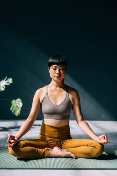 istock Calm Woman Practicing Meditation in Bright Sunlit Room 2179438463