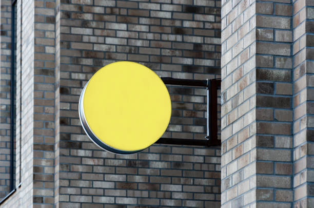 Round blank signboard on street brick wall, space for text, logo, information