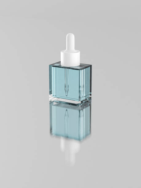 istock beautiful flat square glass dropper bottle mock-up, luxury cubic shape cosmetic bottle standing on reflective floor with close lid plastic cap, single 30 ml pipette dropper glass bottle mockup 2179484765