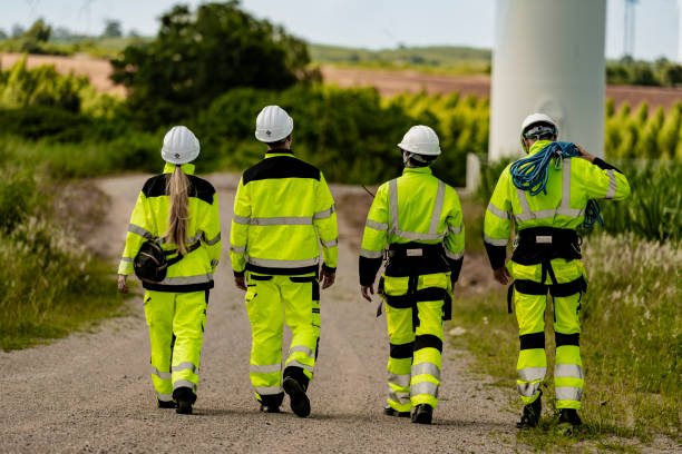 istock group of engineers in high visibility gear stands at a wind farm, observing several wind turbines. The image highlights teamwork, renewable energy, and the scope of wind power projects. 2179489305
