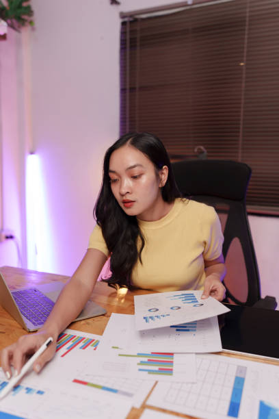 istock Asian woman sitting at work, busy with documents, stressed face, busy with work. 2179493979