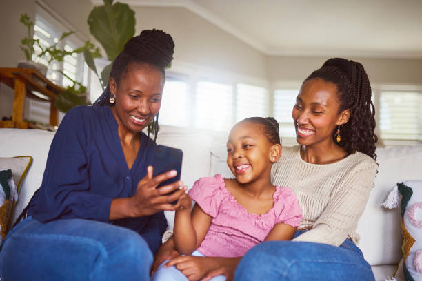 istock Cheerful three generation family using cellphone on sofa at home 2179497293