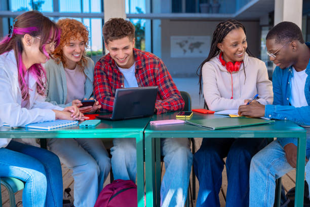 istock A group of students with laptops sit near the campus and communicate. 2179500693