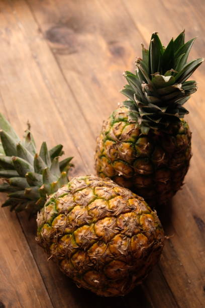 istock two pineapples on wooden table. Ananas comosus. tropical fruit 2179506329