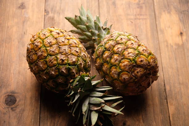 istock two pineapples on wooden table. Ananas comosus. tropical fruit 2179506343