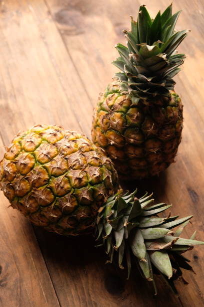 two pineapples on wooden table. Ananas comosus. tropical fruit.