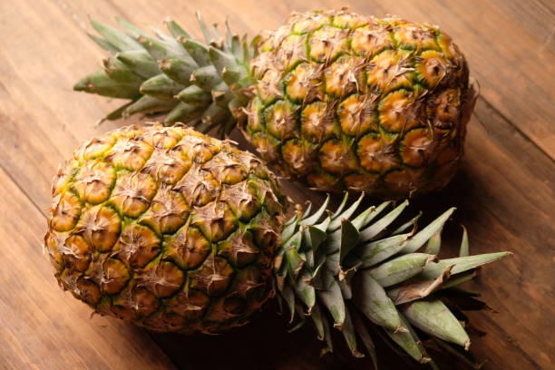 istock two pineapples on wooden table. Ananas comosus. tropical fruit. 2179506348