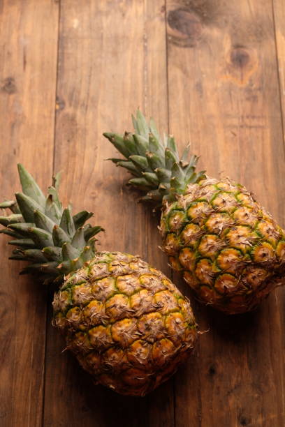 istock two pineapples on wooden table. Ananas comosus. tropical fruit 2179506518