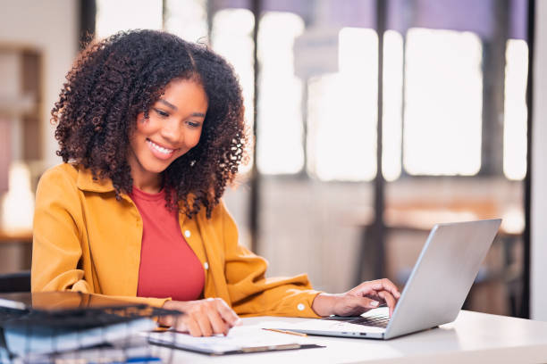 istock Beautiful professional woman sitting at table smiling while reading important documents with financial graphs and accounting of company. 2179509505