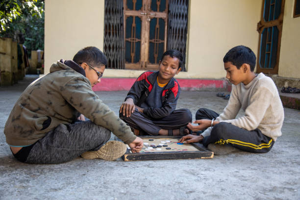 istock Three Children Playing Carrom Board Game Outdoors 2179510889