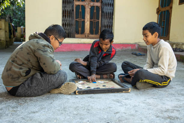 istock Three Children Playing Carrom Board Game Outdoors 2179510898
