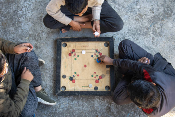istock Three Children Playing Carrom Board Game Outdoors 2179510909