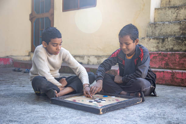 istock Two Children Playing Carrom Board Game Outdoors 2179510935