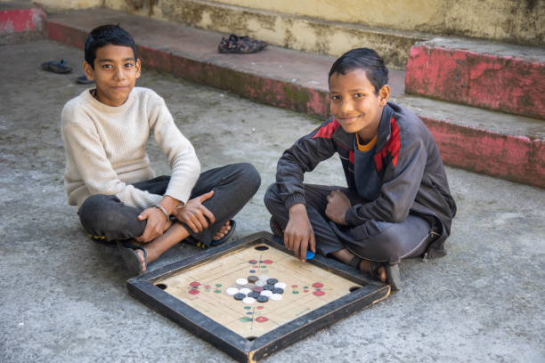 istock Two Children Playing Carrom Board Game Outdoors 2179510974
