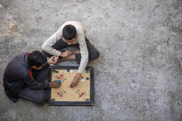 istock Two Children Playing Carrom Board Game Outdoors 2179510991