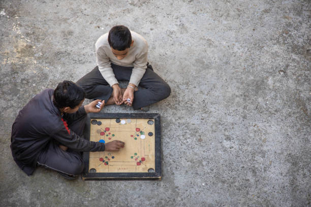 istock Two Children Playing Carrom Board Game Outdoors 2179510995