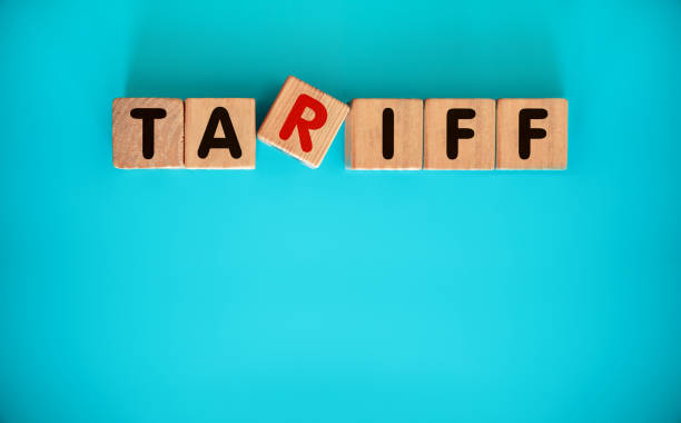 TARIFF word on wooden block on blue background.