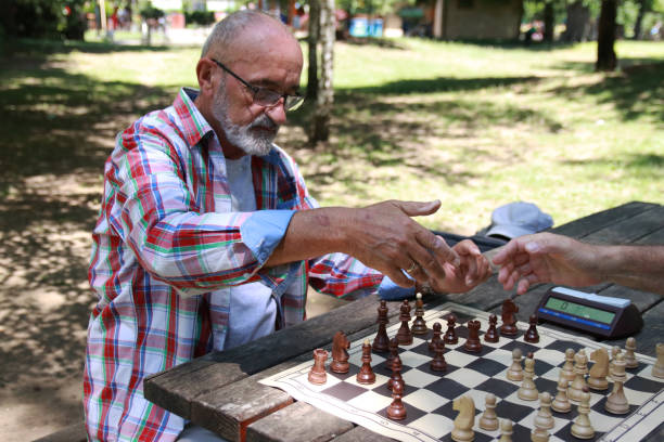 istock Two senior men playing chess in public park 2179517597