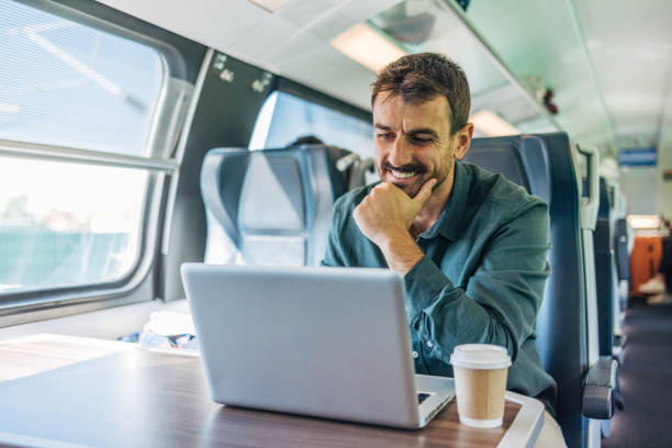 istock A mid-adult, cheerful, handsome man traveling by train. 2179522933