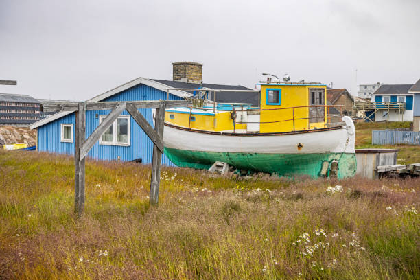 Ilulissat, Jakobshavn, Greenland, Denmark - August 30th 2024: Fishing boat placed on land in a residential district in preparation for the coming winter season