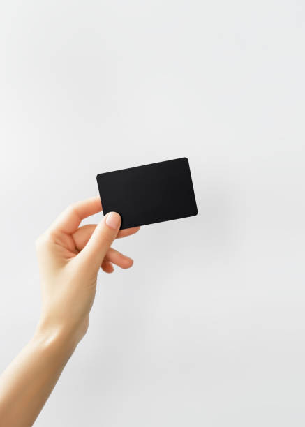 istock hand holding a blank black plastic card on a grey background 2179525974